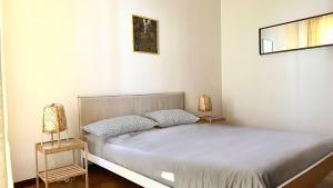 a white bedroom with a bed and two lamps at N294 - Numana, ampio quadrilocale con giardino e wifi in Numana