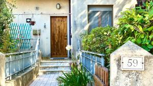 a front door of a house with a wooden door at N294 - Numana, ampio quadrilocale con giardino e wifi in Numana