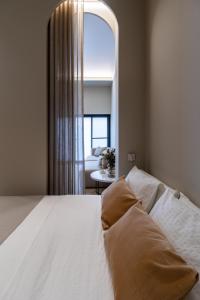 a bedroom with a large white bed with a window at Valencia Malvarrosa point beige in Valencia