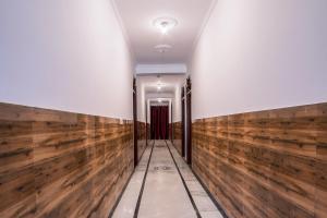 a hallway with wooden walls and a door at Hotel O krishna in Noida