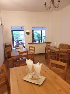 a dining room with wooden tables and wooden chairs at Vila Studio Rasnov cu ciubar si sauna in Râşnov +19 photos