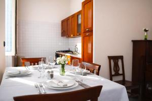 a dining room table with a white table cloth and chairs at WHOLE HOLIDAY HOME APARTMENT SPLENDID CIVITAVECCHIA da Pamino & Priscilla in Civitavecchia +9 photos