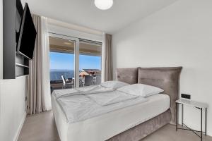 a bedroom with a bed with a view of the ocean at Apartment Adriatic Pearl -Makarska Exklusiv in Tučepi