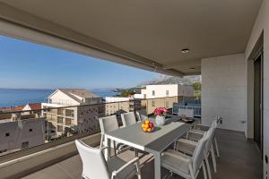 a table and chairs on a balcony with a view at Apartment Adriatic Pearl -Makarska Exklusiv in Tučepi
