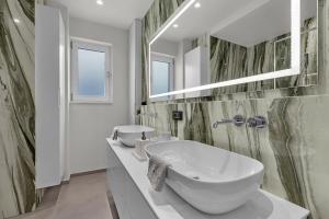 a bathroom with a large white sink and a mirror at Apartment Adriatic Pearl -Makarska Exklusiv in Tučepi +22 photos
