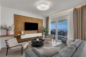 a living room with a couch and chairs and a television at Apartment Adriatic Pearl -Makarska Exklusiv in Tučepi