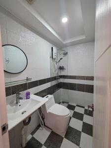 a bathroom with a white toilet and a sink at L Residence 2 BTB in Phnom Penh