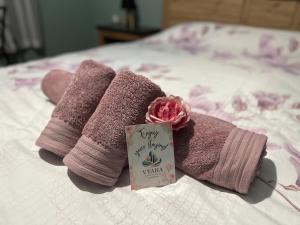 a pair of towels on a bed with a sign at Vyara apartments 56 in Varna City