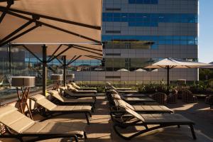 a row of lounge chairs and umbrellas on a roof at Catalonia Gran Hotel Verdi in Sabadell