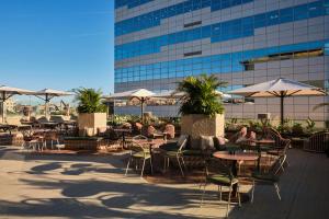 an outdoor patio with tables and chairs and umbrellas at Catalonia Gran Hotel Verdi in Sabadell
