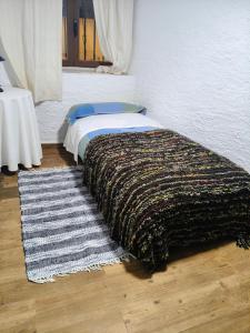 a bedroom with a bed and a rug on the floor at Casa " El Chacho " Velefique in Velefique