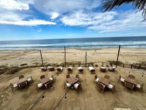 a group of chairs and tables on a beach at The Cerritos Beach Inn in El Pescadero