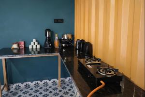 a kitchen with a counter with a stove top oven at Mud Meadows Peace and Tranquility Farm With Pool in Faridabad