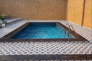 a large swimming pool with a tile floor at Mud Meadows Peace and Tranquility Farm With Pool in Faridabad