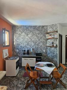 a kitchen with a table and chairs in a room at Kitnet Estrela do Mar in Peruíbe