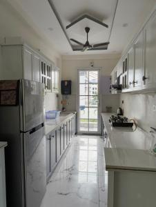 a kitchen with white counter tops and a refrigerator at Stay in peace in Dehradun