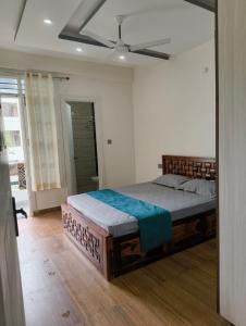 a bedroom with a large bed with a ceiling fan at Stay in peace in Dehradun
