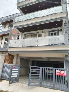 a house with a blue gate and a balcony at Stay in peace in Dehradun
