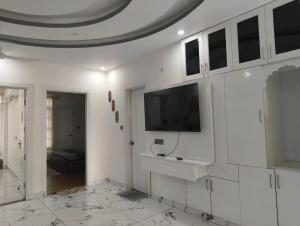 a white room with a tv on a wall at Stay in peace in Dehradun