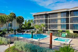 a swimming pool in front of a building at Pine Cove #304 in Ybel