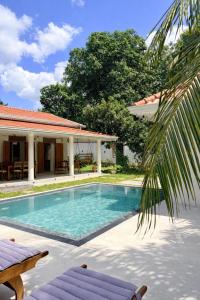 a swimming pool in front of a house at Madhu Villa in Weligama