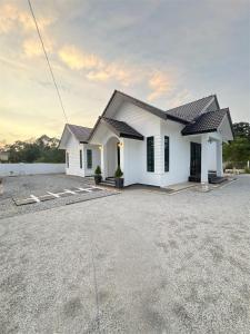 a white house with a driveway in front of it at Husna WhiteStay Modern Luxury Family Home spacious 1700sqft Gated Parking in Bukit Payong