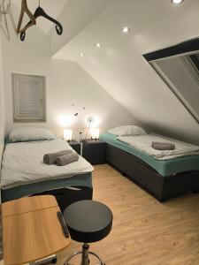 a bedroom with two beds and a table and a chair at Helle Wohnung mit zwei Schlafzimmern in Eching