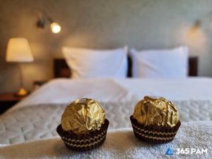 two chocolate muffins are wrapped in foil on a bed at 365PAM - Apartament 5 Mórz - BASEN, PLAC ZABAW, PARKING W CENIE in Sianozety