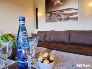 a bottle of wine sitting on top of a table at 365PAM - Apartament 5 Mórz - BASEN, PLAC ZABAW, PARKING W CENIE in Sianozety +23 photos