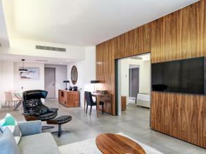 a living room with a large flat screen tv at St Raphael Resort & Marina in Limassol