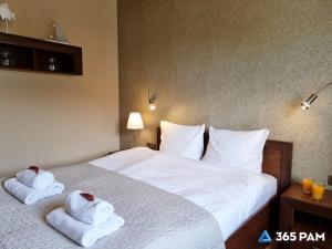 a bedroom with a bed with towels on it at 365PAM - Apartament 5 Mórz - BASEN, PLAC ZABAW, PARKING W CENIE in Sianozety