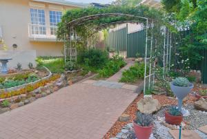 a garden with an arbor and a patio at Naval Hill Nook in Bloemfontein