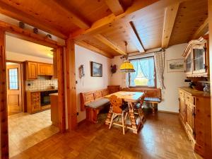 a kitchen with wooden cabinets and a table and chairs at FeWo Reserl in Bischofswiesen