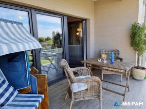 a patio with a table and chairs on a porch at 365PAM - Apartament 5 Mórz - BASEN, PLAC ZABAW, PARKING W CENIE in Sianozety
