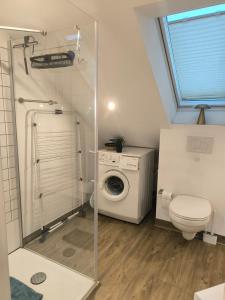 a bathroom with a toilet and a washing machine at Helle Wohnung mit zwei Schlafzimmern in Eching +4 photos