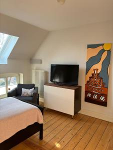 a bedroom with a bed and a flat screen tv at Villa Friedenstraße 11 in Lüneburg