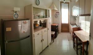 a kitchen with a refrigerator and a table in it at Casa da Rosa in Sezze