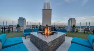 a fire pit on the roof of a building with blue furniture at Condo in downtown oak city highrise in Raleigh