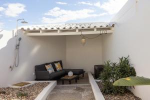 a patio with a black couch under a pergola at The Bliss House in Lourinhã