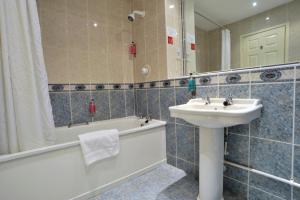 a bathroom with a sink and a bath tub and a sink at Keswick Country House Hotel in Keswick +45 photos