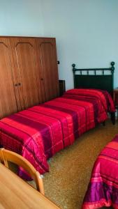 two beds with red sheets in a room at Casa da Rosa in Sezze +7 photos