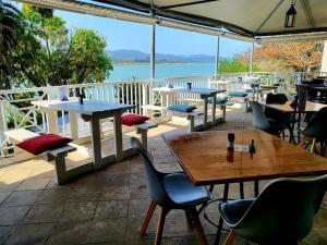 a patio with tables and chairs and a view of the water at Lake Pleasant Hotel in Sedgefield