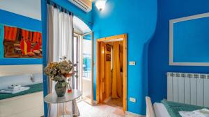 a blue room with a vase of flowers on a table at Casa Zefiro by Rentbeat in Ostuni