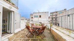 a patio with a table and chairs on a balcony at Casa Zefiro by Rentbeat in Ostuni