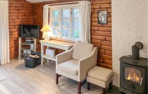 a living room with a desk and a chair and a stove at Amazing Home In Hundested With Wifi in Hundested