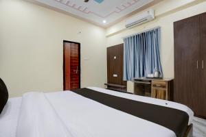 a bedroom with a large white bed and a window at Hotel O by OYO SGD Lawn And Hotel in Varanasi