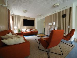 a living room with orange chairs and a couch at EnjoyNature Resort in Lahti