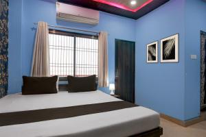 a bedroom with a bed and a blue wall at Hotel O by OYO Shree Paying Guest House in Varanasi