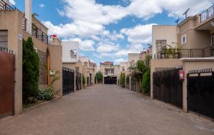an empty street in a residential neighbourhood with houses at Perfect Palm Condos-N12 in Nakuru