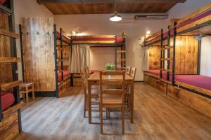 a room with a table and chairs and bunk beds at Turn Hostel in Ljubljana